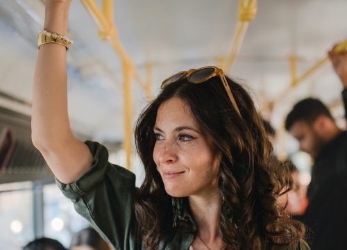 Photo of a woman using public transportation on a bus