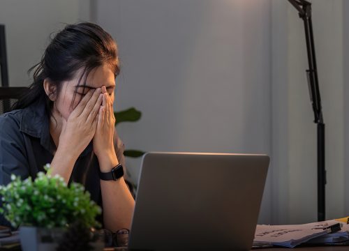 Photo of a woman working from home, experiencing brain fog at her desk