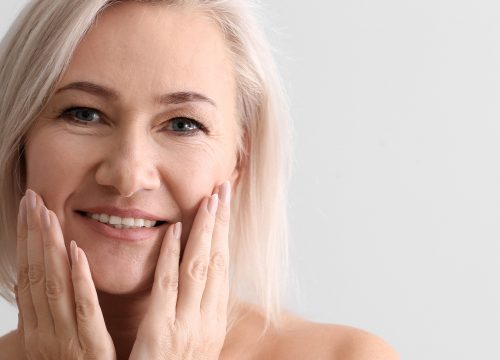 Photo of an older woman touching her face
