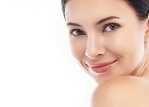 Close-up portrait of a woman with bare shoulders against a white background
