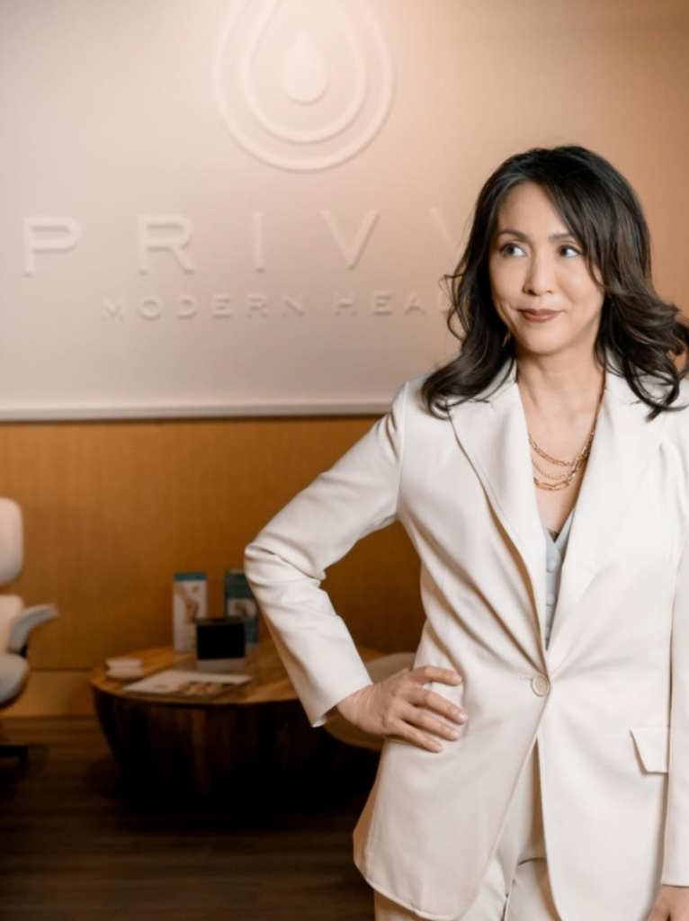 Woman with eyes closed touching her cheek near a window