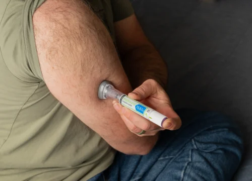 Injection pen pressed against upper arm during self injection