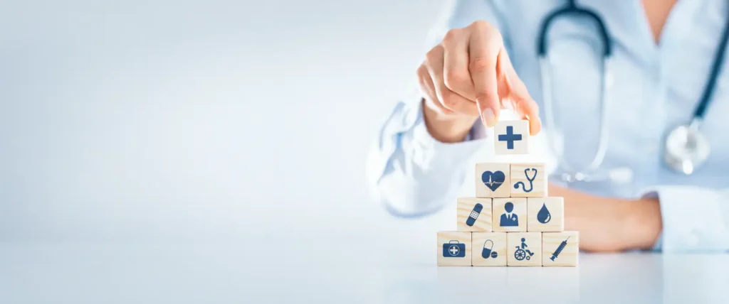 Healthcare professional stacking medical icon blocks on a desk