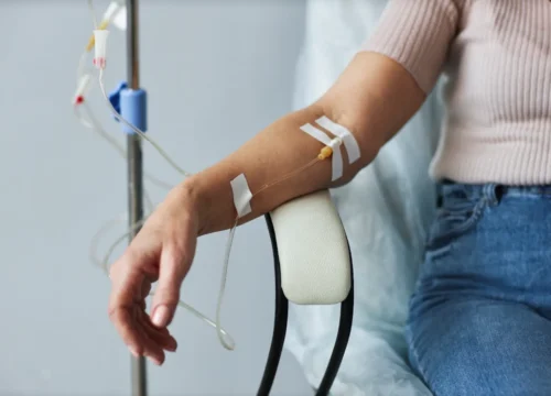 Woman seated with IV infusion connected to her arm during treatment