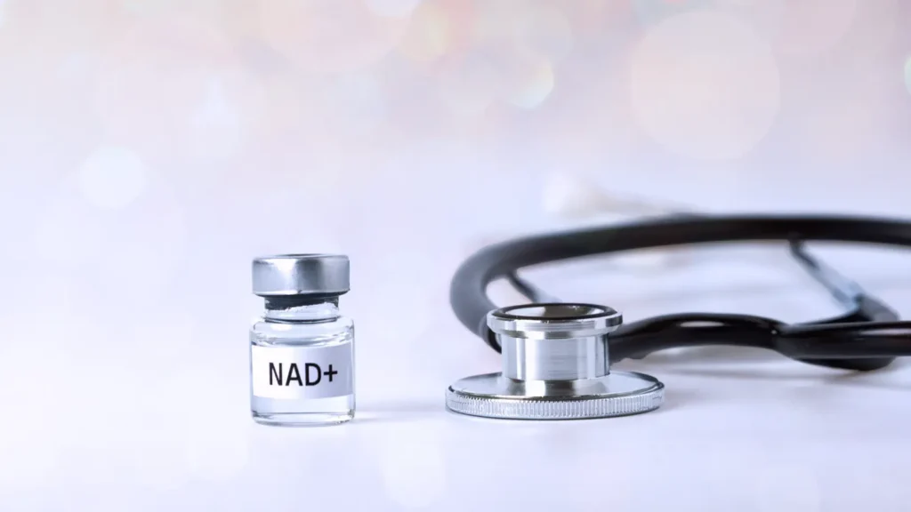 Vial labeled NAD+ beside a stethoscope on a white surface.